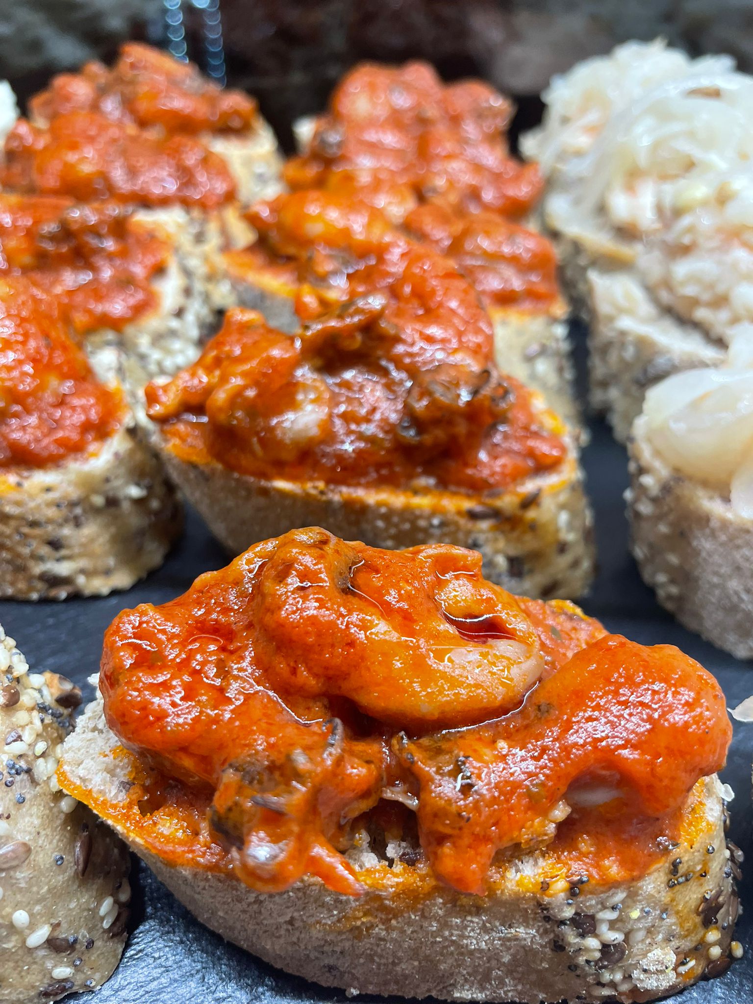 Cicchetti veneziani con frutti di mare in salsa rossa, bacaro Venezia